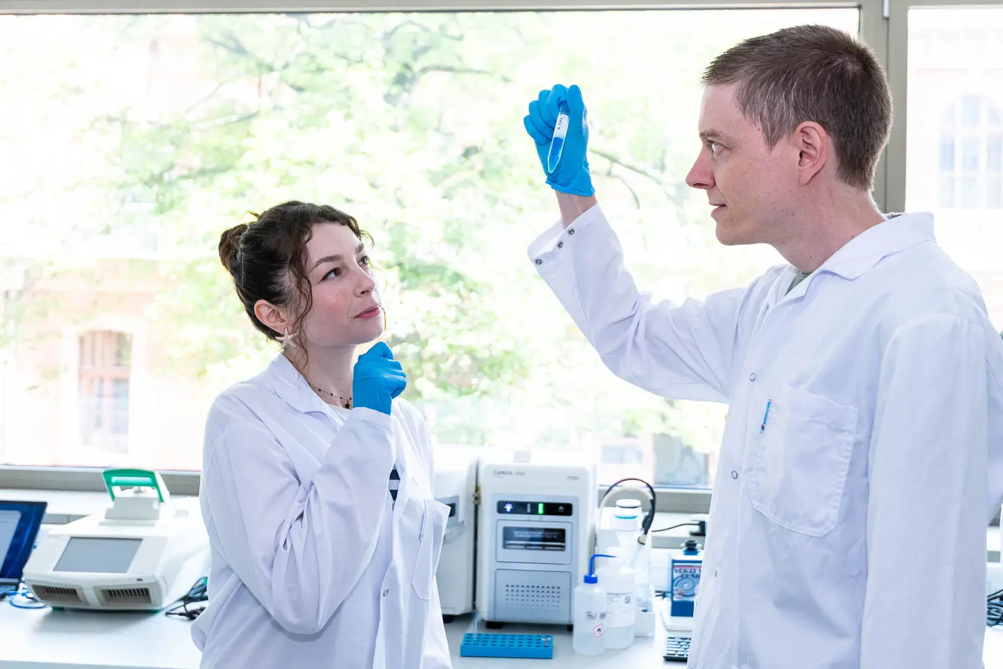 Forscherin bei der Probenanalyse waehrend Kollegin zuschaut im Biotech-Labor, Wien