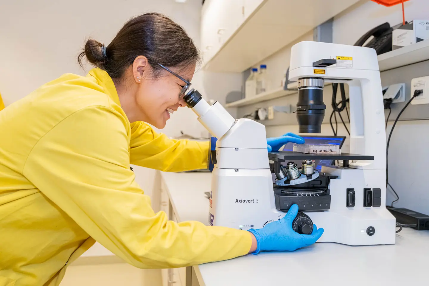 Forscher arbeitet am Axiovert-Mikroskop im Biotech-Labor, Business Fotograf Wien