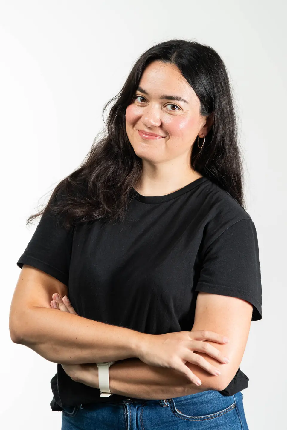 Frau mit Creolen-Ohrringen und verschraenkten Armen im Business Portrait, Wien