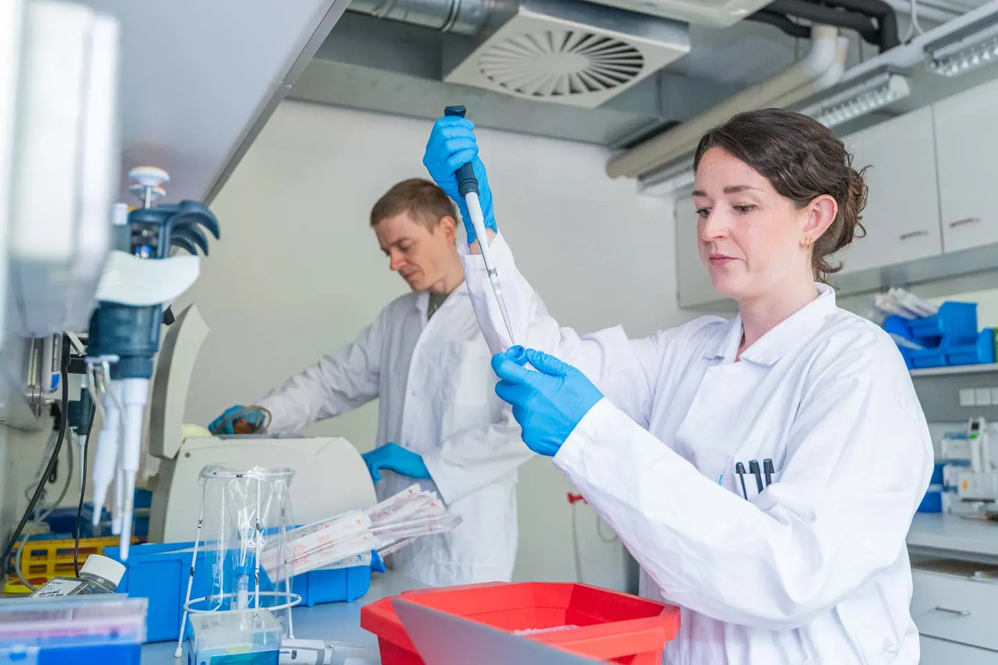 Wissenschaftlerin hebt eine Pipette im Laborportrait, Corporate Headshot Wien