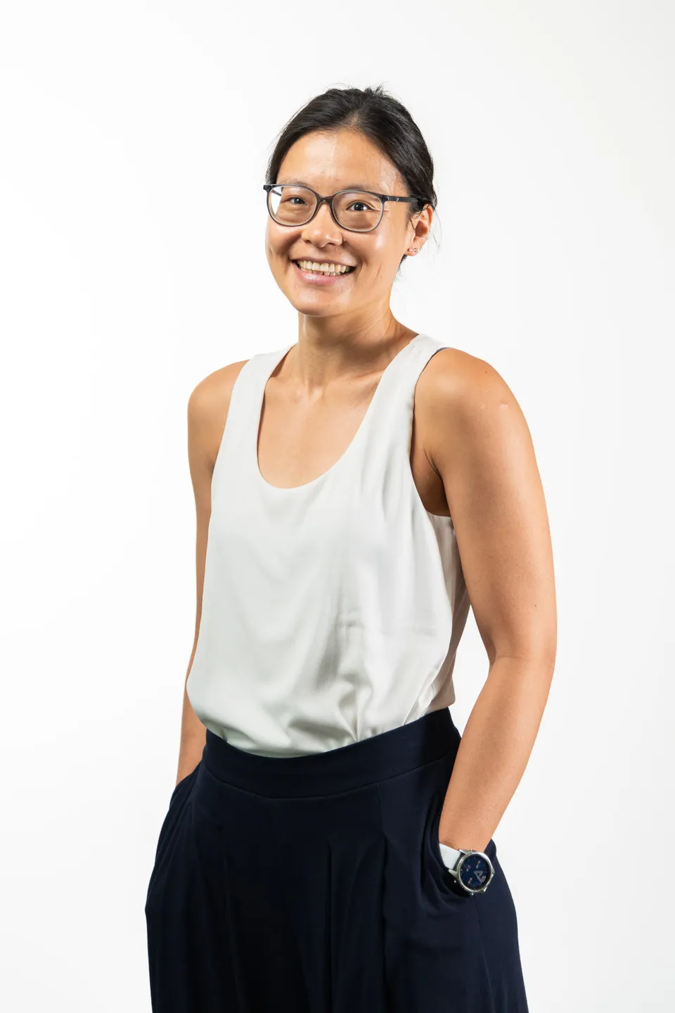 Frau mit Brille und weissem Top, Hand in der Tasche, Firmenfotograf Wien
