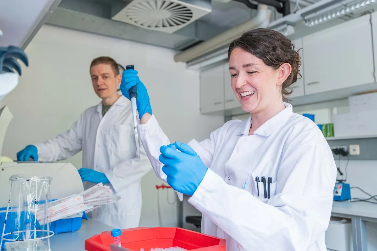 Natuerlich lachende Forscherin im Biotech-Labor waehrend der Arbeit, Firmenfotograf Wien