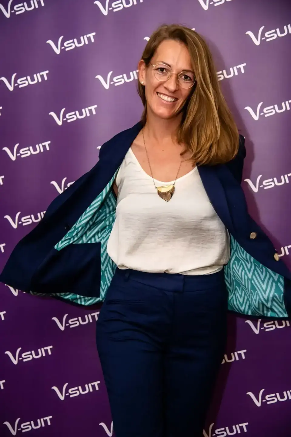Frau in eleganter Businesskleidung vor V-SUIT Backdrop bei Eventfotografie Wien