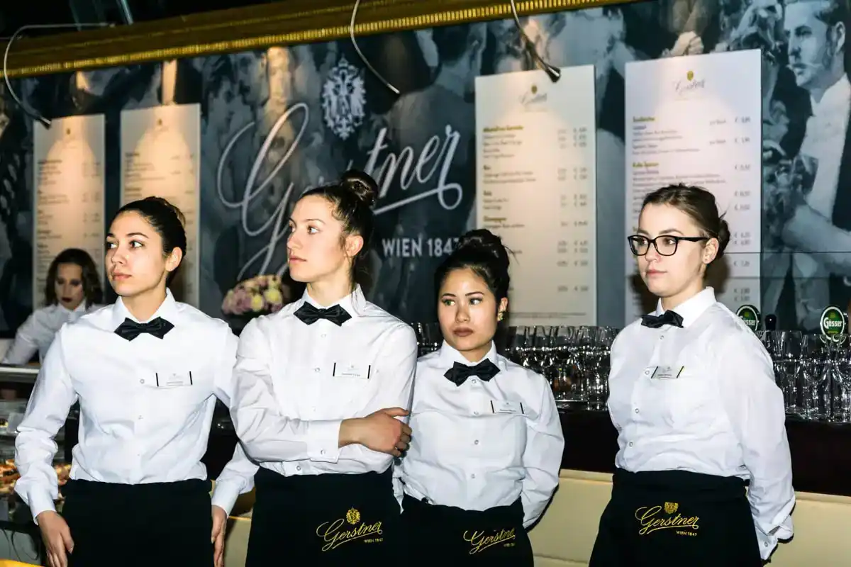 Vier Kellnerinnen in eleganter Servicekleidung bei einem Hofburg-Event in Wien, professionelle Eventfotografie