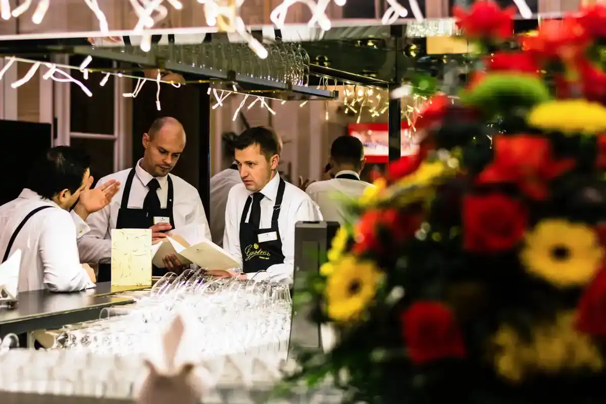 Bartender serviert Gästen an der Bar während eines eleganten FirmenEvents in der Hofburg Wien mit weihnachtlicher Dekoration