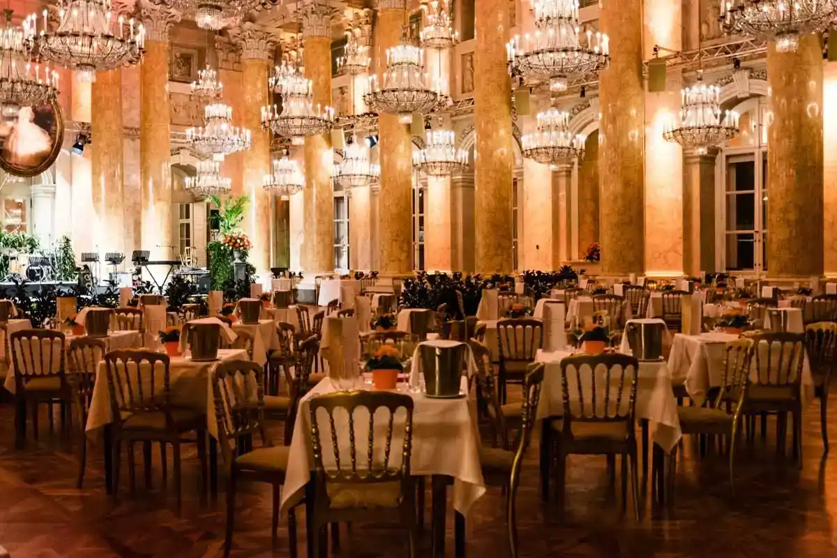Eleganter Ballsaal in der Hofburg Wien mit Kristallleuchtern, gedeckten Tischen und Stühlen - professionelle Eventfotografie
