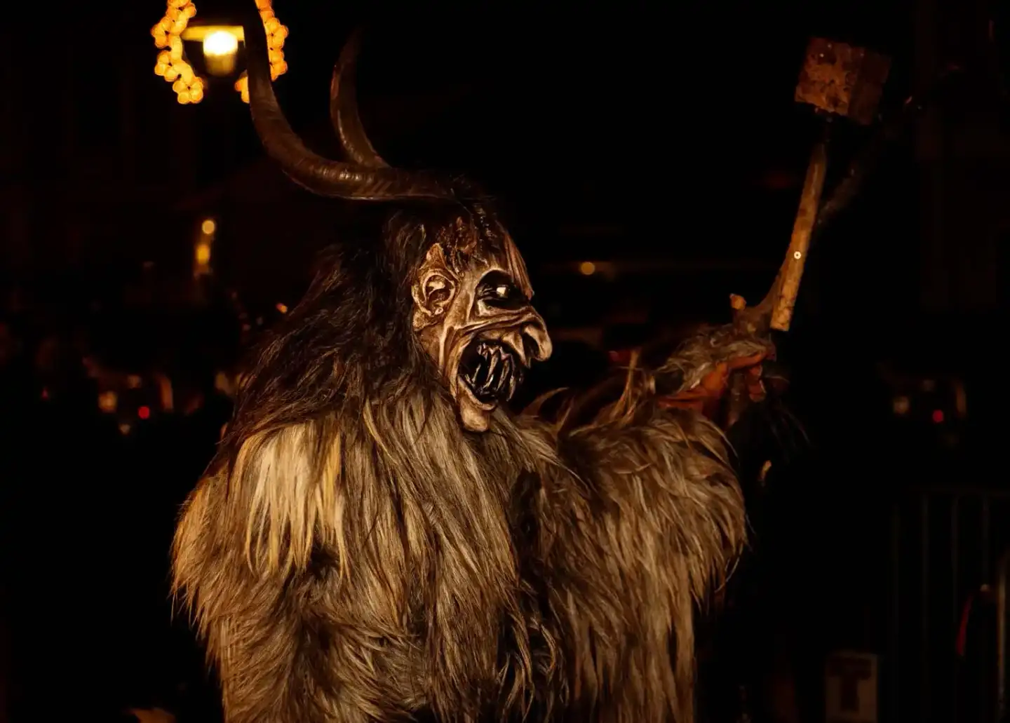 Krampus-Figur mit Hörnern und beängstigender Maske bei Eventfotografie in Wien, dramatisch von oben beleuchtet