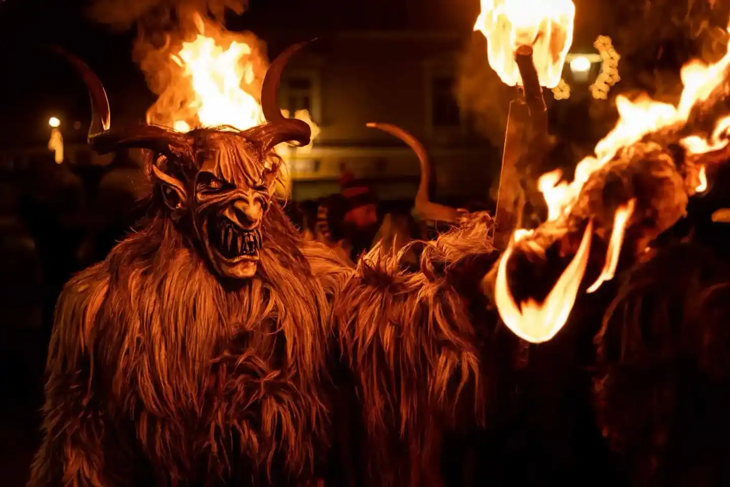 Krampus-Figur mit Hörnern und Fell bei Fackelfeuer-Performance, professionelle Eventfotografie Wien