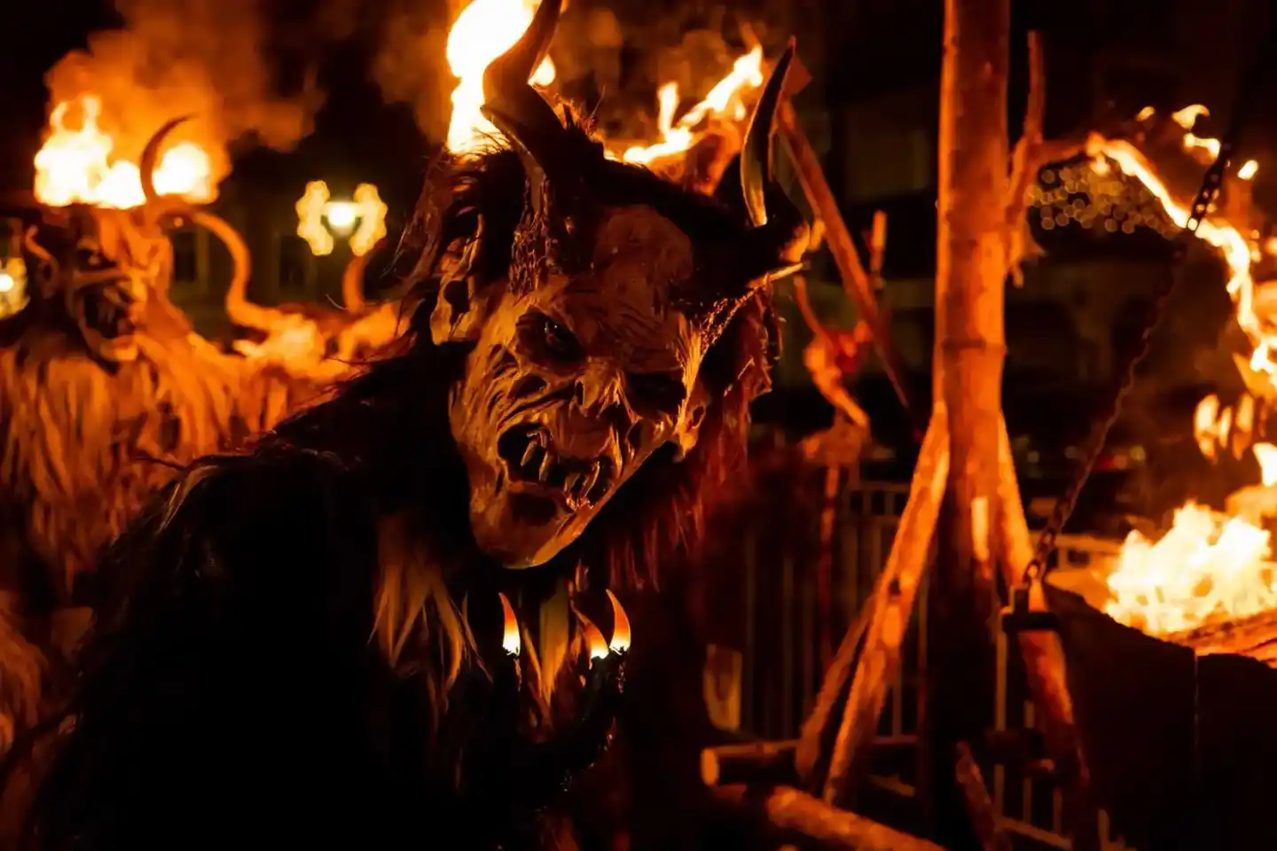 Krampus-Figur mit Feuer im Hintergrund bei Eventfotografie Wien - traditionelle österreichische Krampuslauf-Veranstaltung