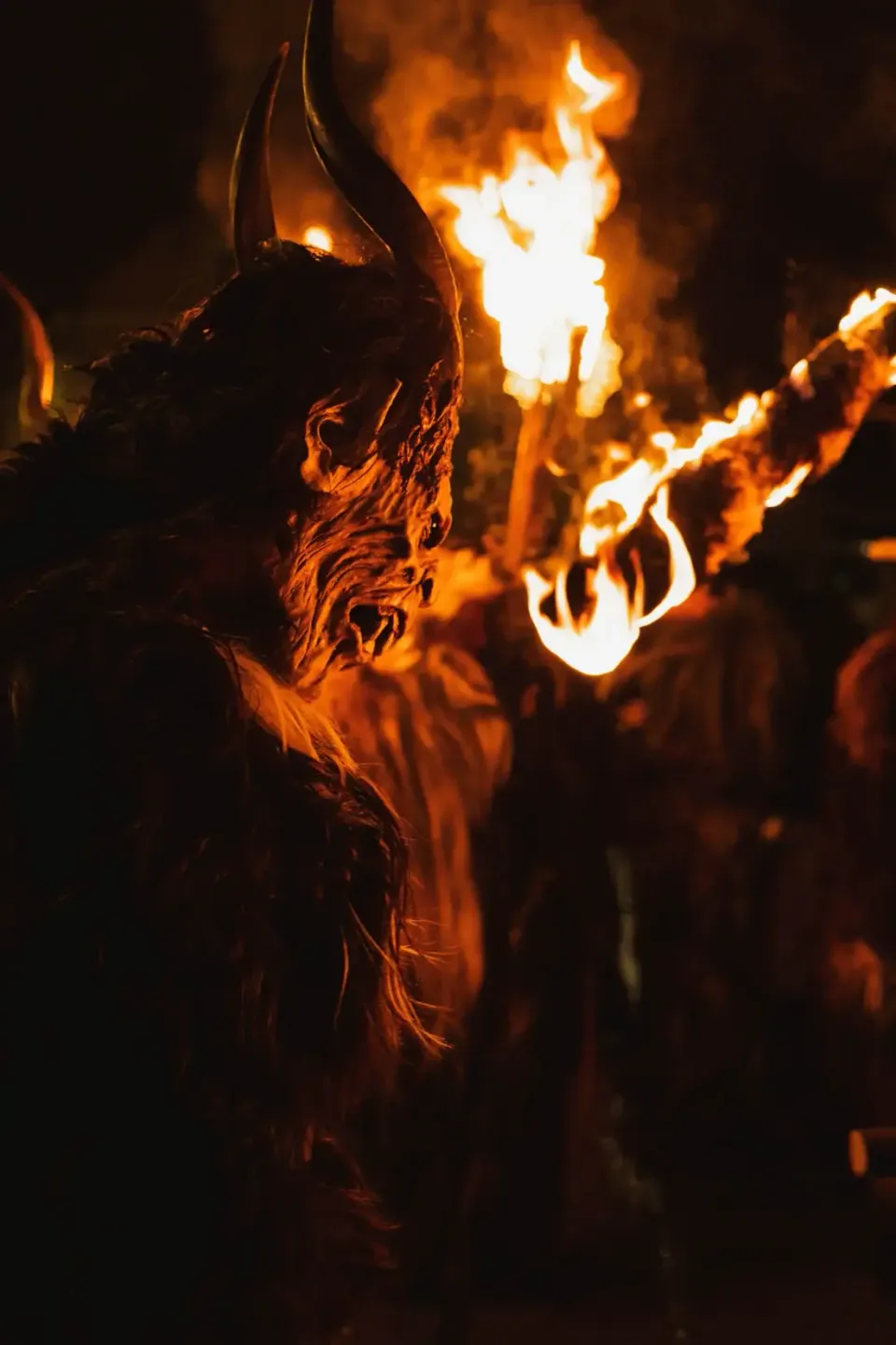 Krampus-Figur mit brennenden Fackeln bei Eventfotografie Wien - dramatische Nachtaufnahme eines traditionellen Spektakels
