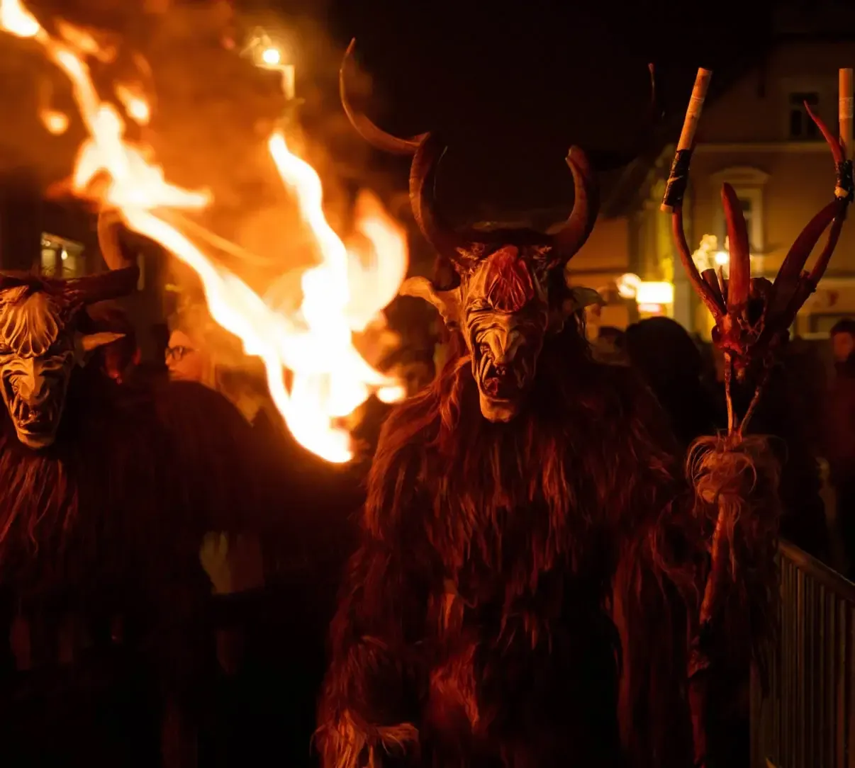 Krampus-Figuren mit Hörnern und Feuerfackeln bei nächtlicher Eventfotografie in Wien
