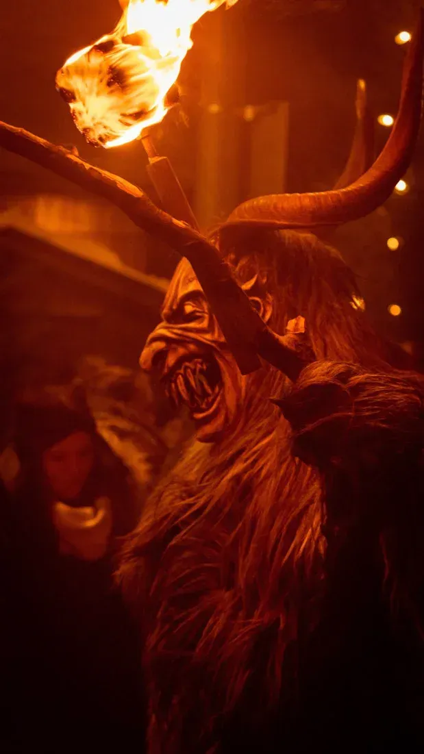 Krampus Figur mit brennender Fackel bei Veranstaltungsfotografie Wien, dramatisch beleuchtete Eventfotografie