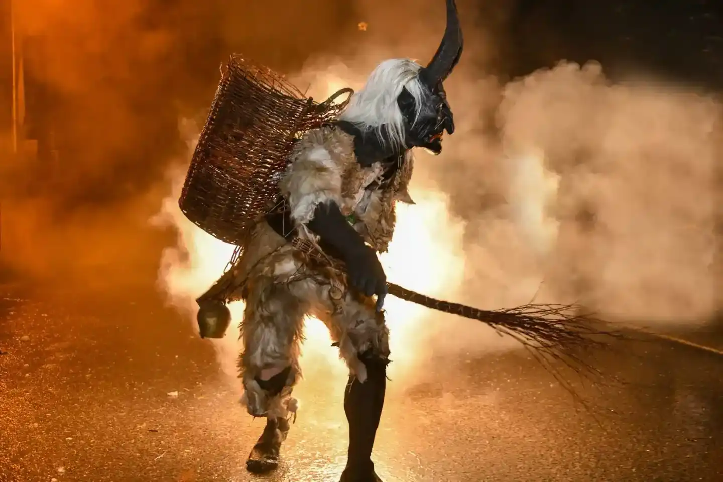 Krampus-Figur mit Hörnern, weißem Haar und Korb bei Nachtveranstaltung - Eventfotografie Wien