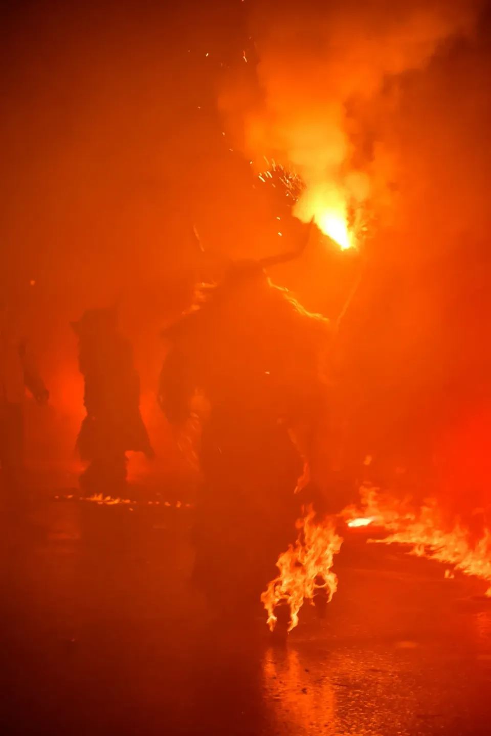 Krampus-Feuershow bei Nacht mit brennenden Fackeln und Feuer, professionelle Eventfotografie Wien