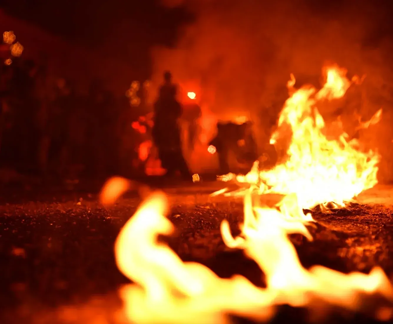 Krampus Event in Wien: Flammen und Feuer bei einer Veranstaltung, Besucher stehen um das Lagerfeuer herum in der Nacht