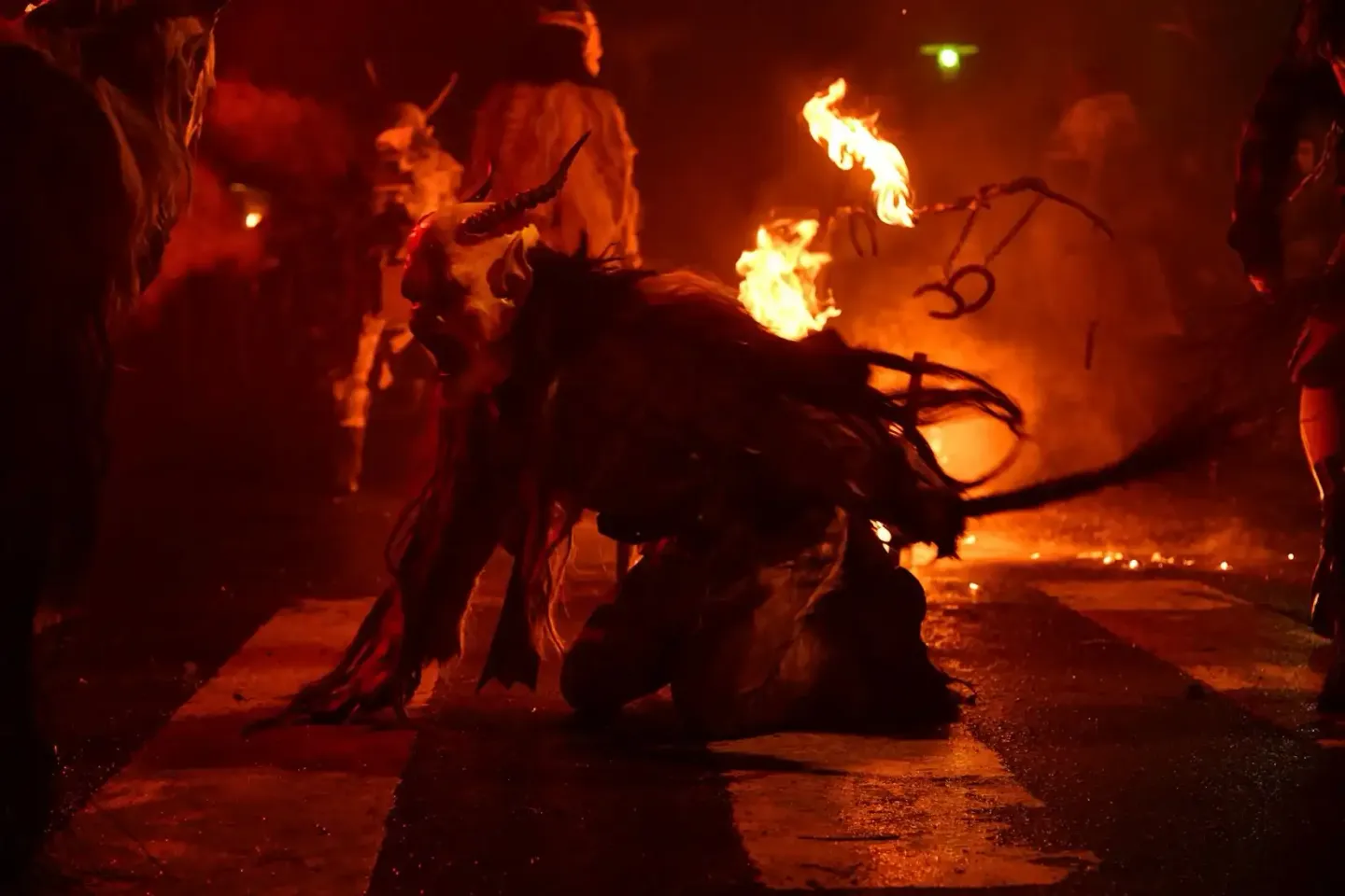 Feuerspucker bei Krampus-Event Wien mit brennenden Feuerfackeln und Publikum in orangerotem Licht