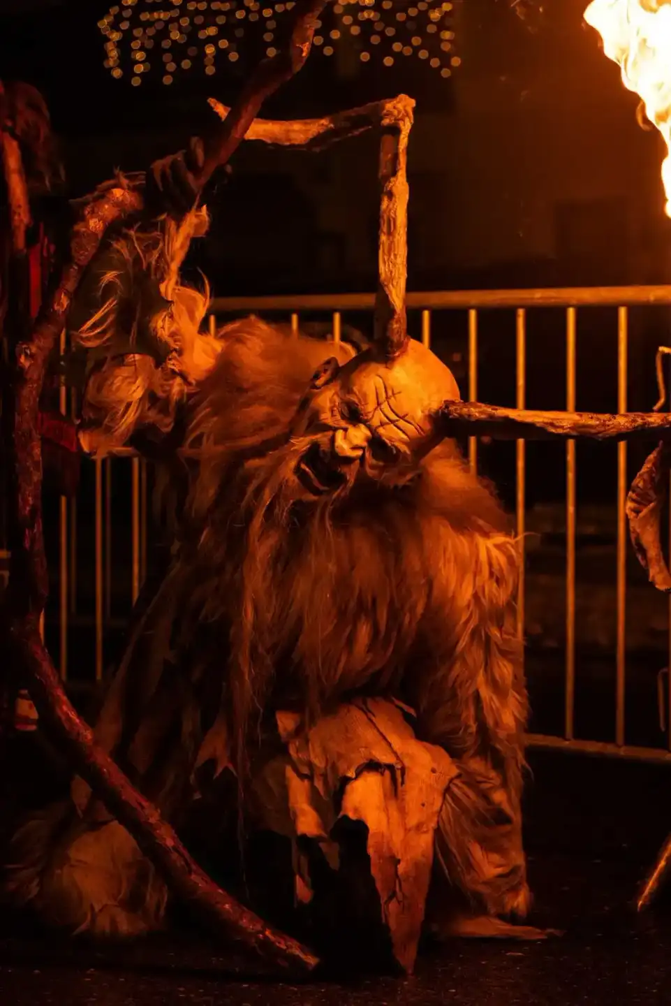 Krampus-Figur in aufwendigem Kostüm bei Eventfotografie Wien, dramatisch beleuchtet vor Metallgitter