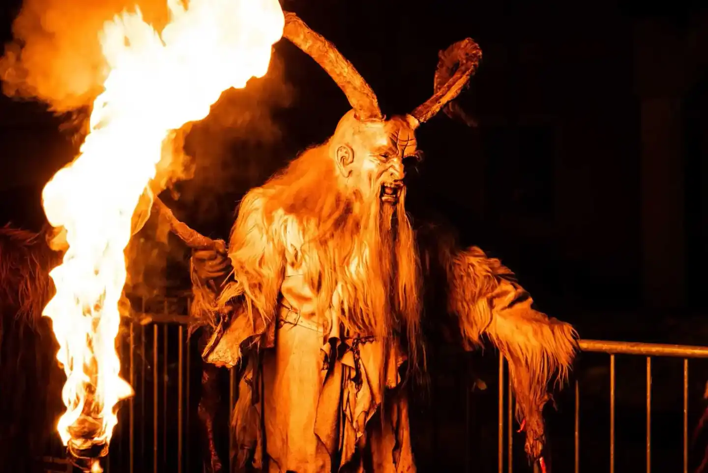 Krampus-Figur mit Feuer bei Nacht - Eventfotografie Wien zeigt traditionelle Krampus-Lauf Inszenierung