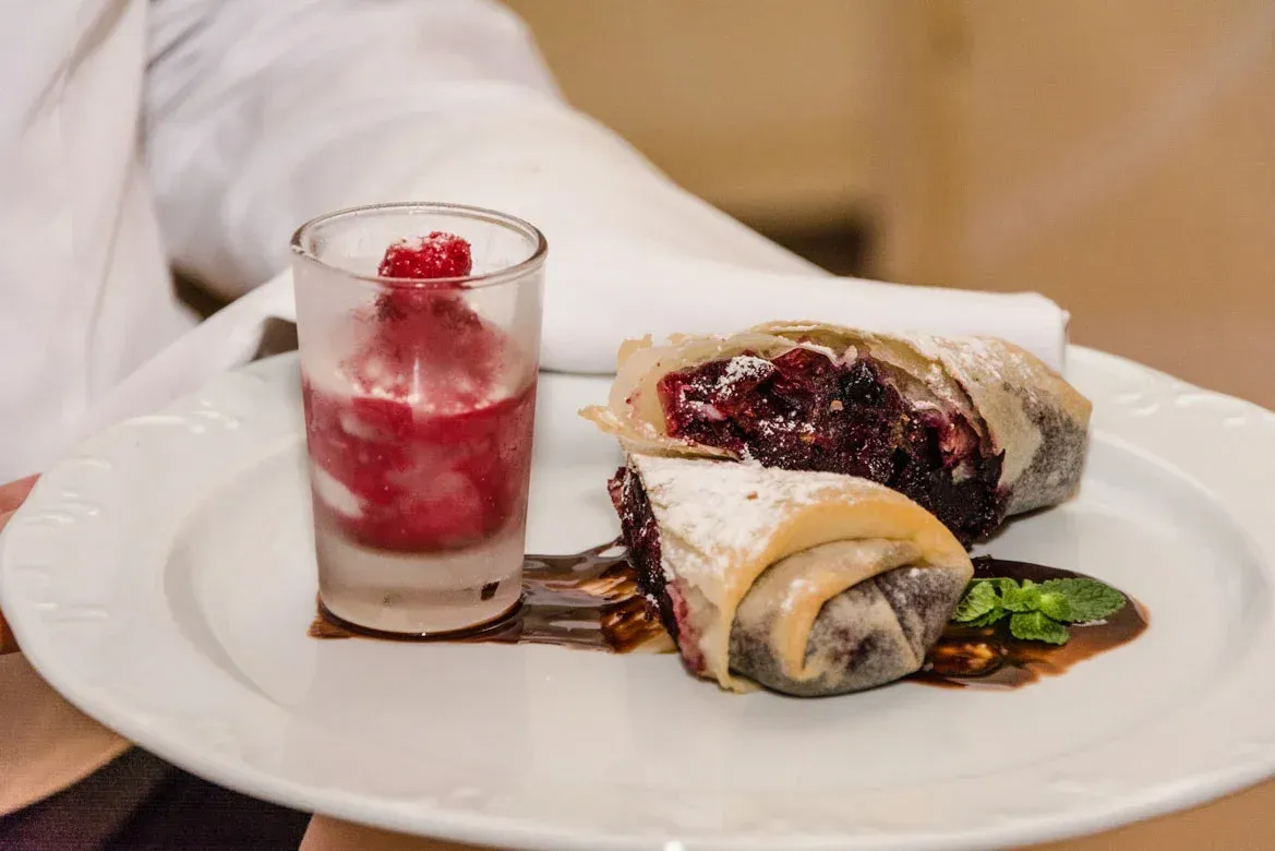 Elegantes Dessert-Arrangement mit rotem Beeren-Strudel und frischer Himbeerbowle bei Eventfotografie Wien