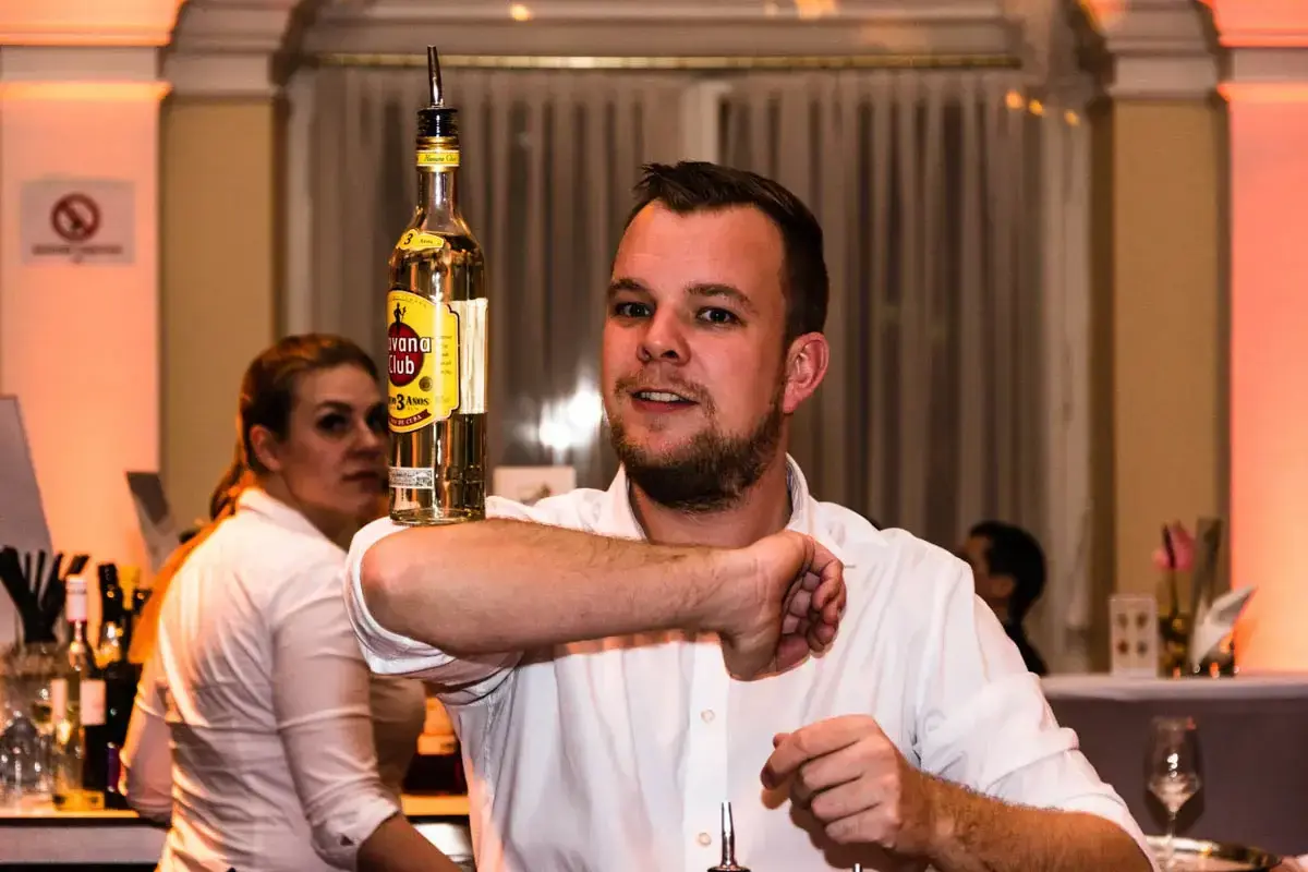 Bartender präsentiert Cocktail mit Flasche beim Kursalon Firmenevent - Eventfotografie Wien