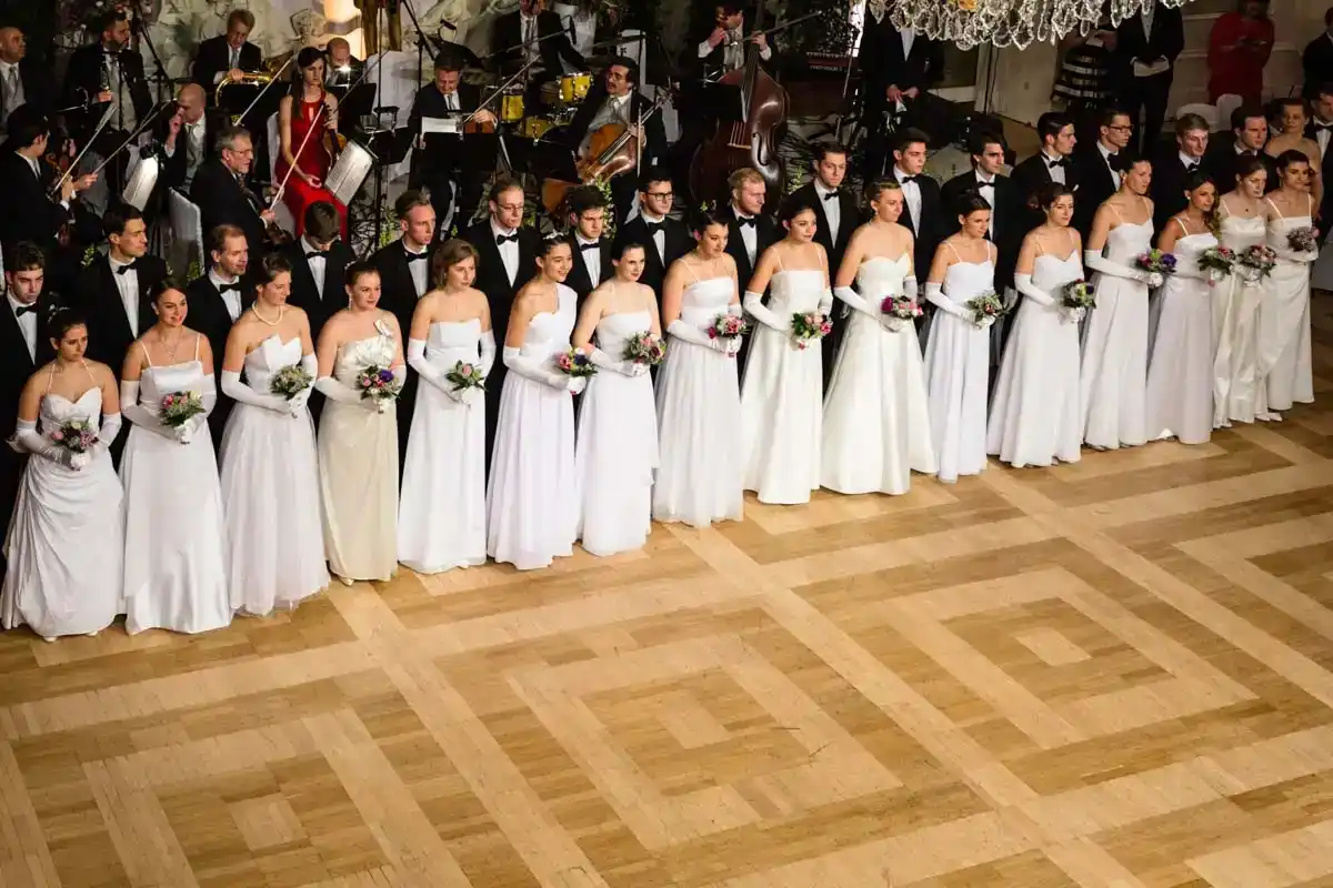 Elegante Hochzeitsgesellschaft im Kursalon Wien mit Brautjungfern in weißen Kleidern und Live-Orchester - Eventfotograf Wien