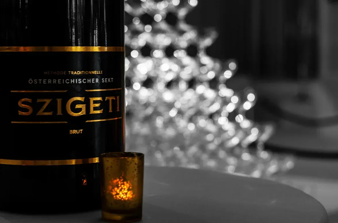 Szigeti Brut Sekt Flasche mit gefülltem Glas vor festlicher Beleuchtung – professionelle Eventfotografie Wien