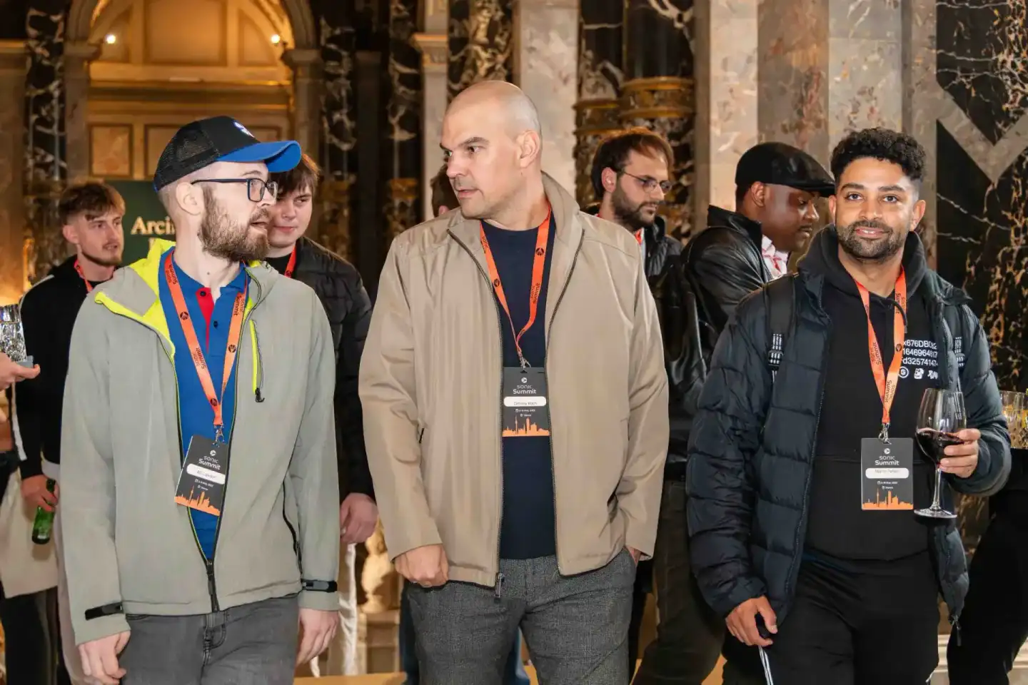 Teilnehmer mit Event-Badges beim Sonic Summit in einem eleganten Wiener Veranstaltungsraum, professionell dokumentiert durch 