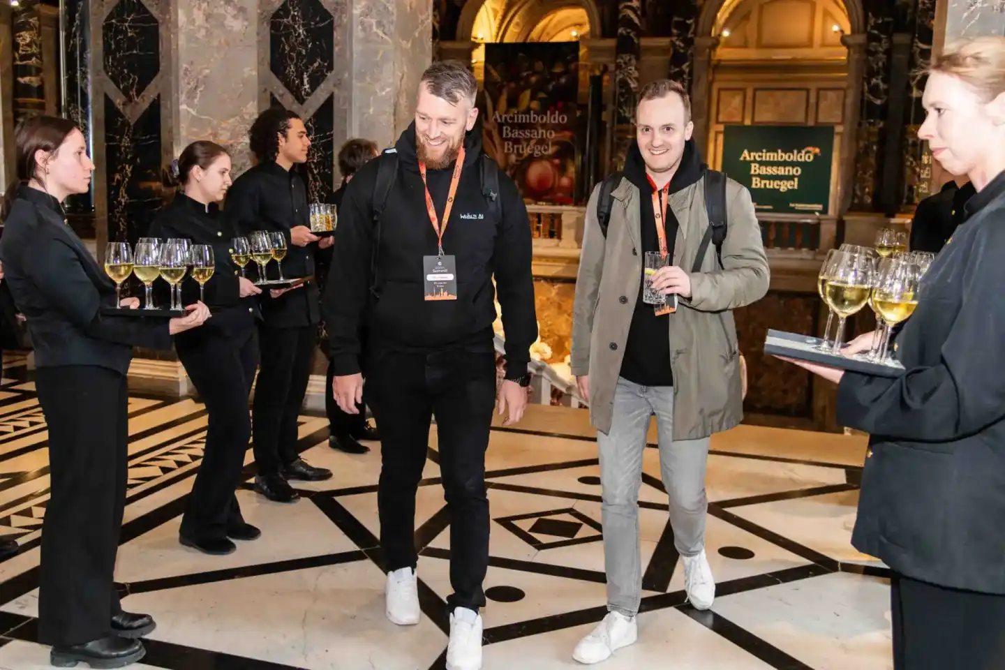 Gäste beim Sonic Summit Firmenevent in Wien genießen Getränke in eleganter Marmorhalle mit goldenem Gewölbe