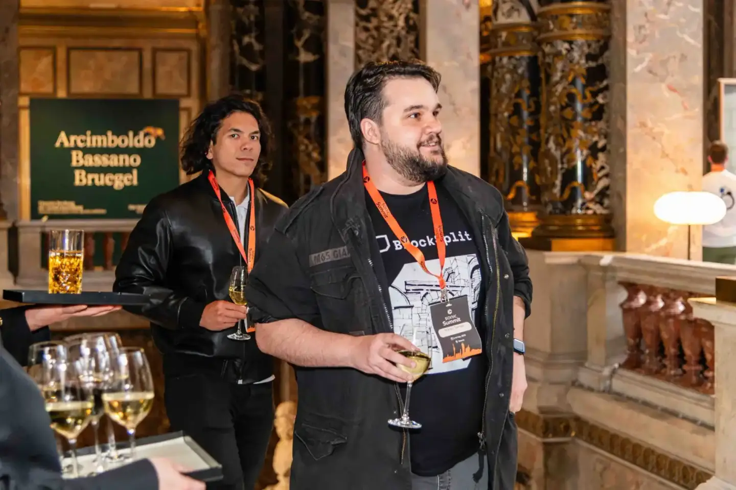 Zwei Redner mit Lanyards beim Sonic Summit Event in einem prunkvollen Saal mit Goldverzierungen – professionelle Eventfotogra