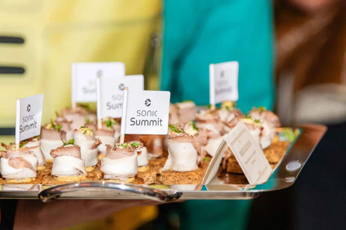 Appetitappen mit Mozzarella und Schinken auf Crackern mit Sonic Summit Fahnen bei einem Firmenevent Wien