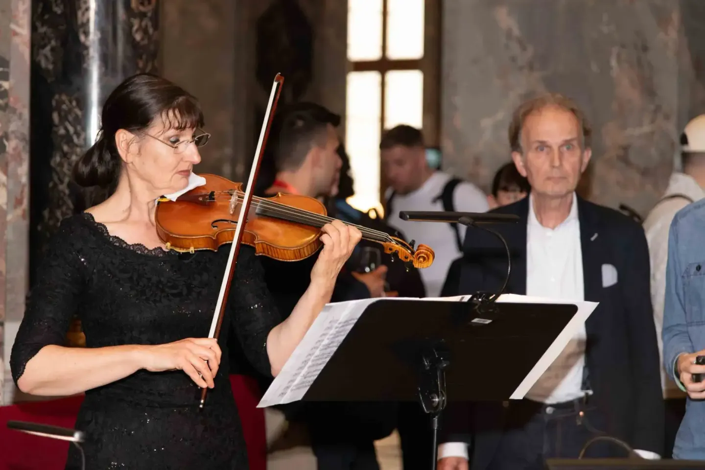 Violinistin mit Brille spielt bei Sonic Summit Event vor Publikum in historischem Wiener Saal