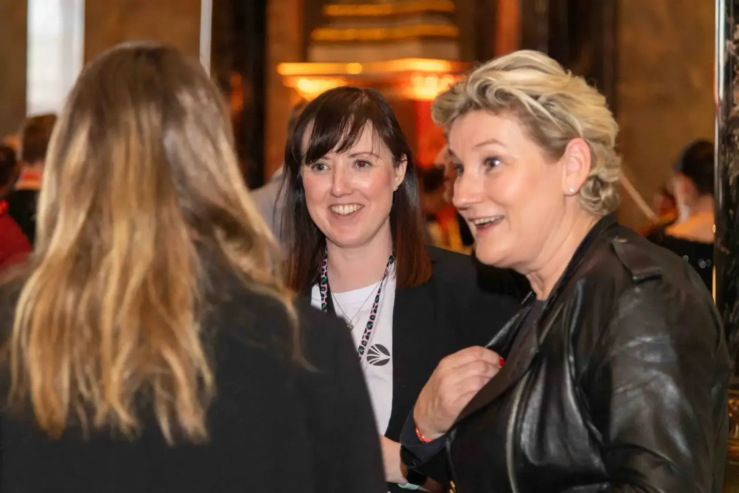 Drei Frauen in Business-Kleidung im Gespräch bei einem Firmenevent, Eventfotograf Wien dokumentiert die Networking-Situation
