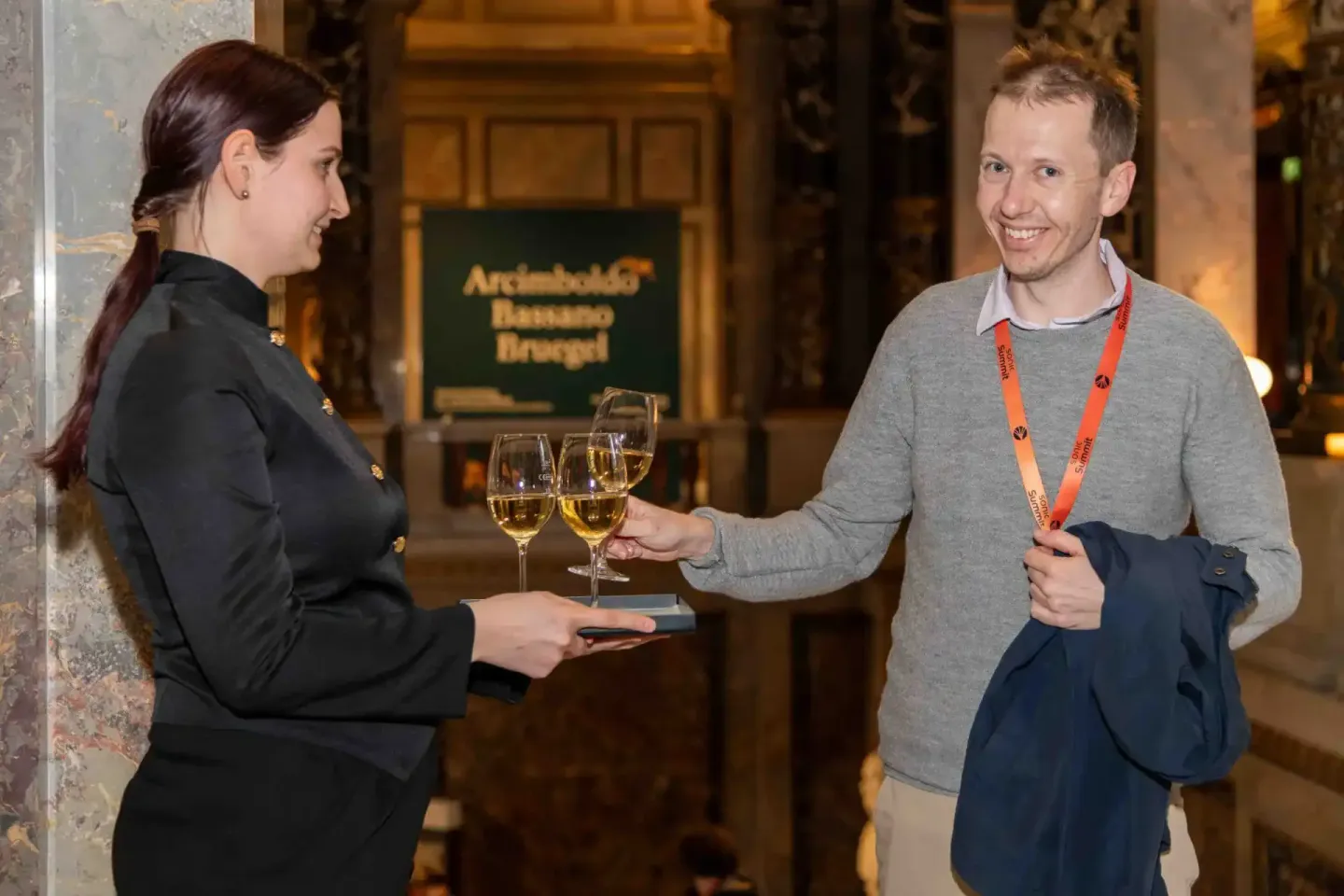 Eventfotograf dokumentiert Networking-Moment beim Sonic Summit mit zwei Personen beim Anstoßen mit Weingläsern in eleganter W