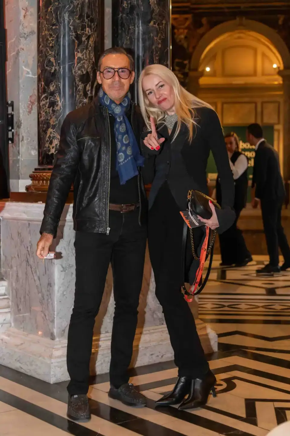 Zwei elegant gekleidete Personen bei einem Firmenevent Wien in einer stilvollen Halle mit Marmorsäulen