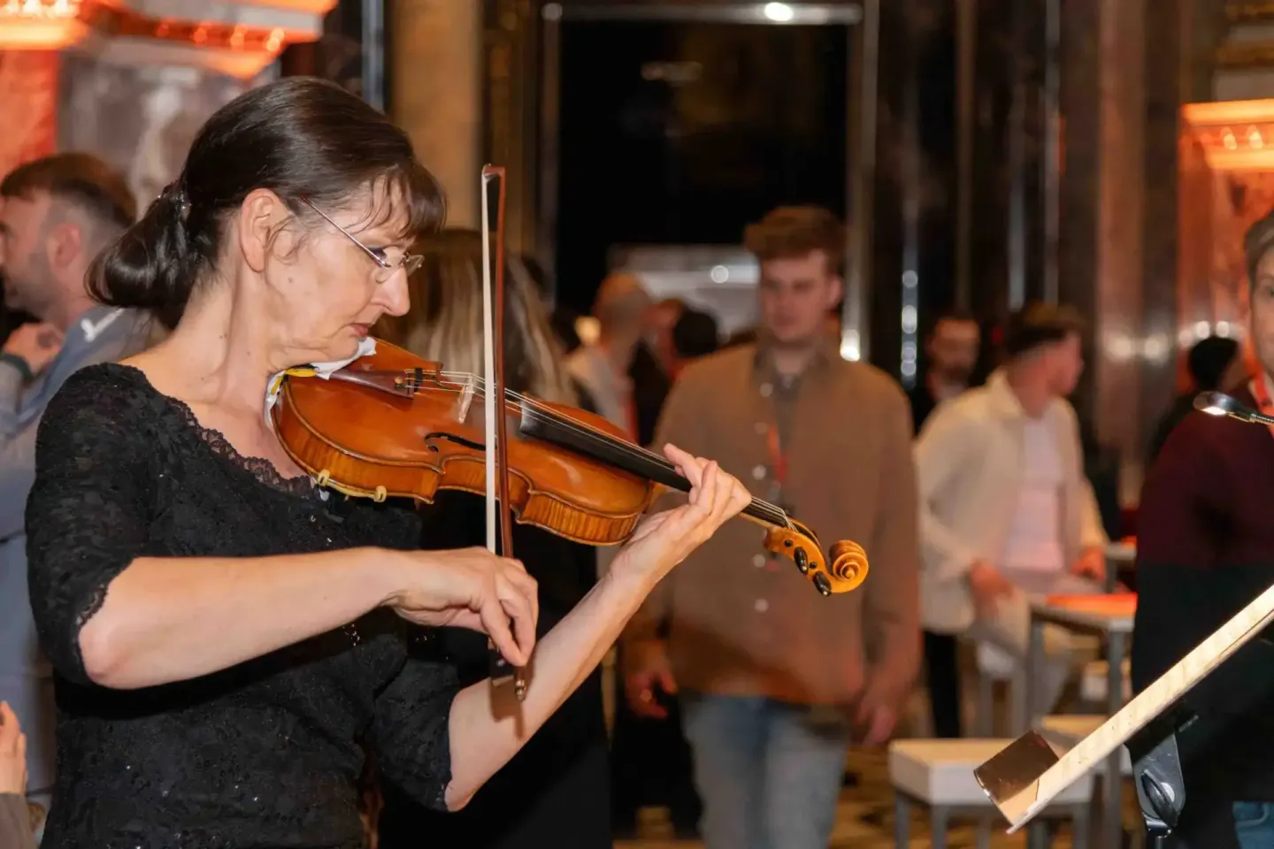 Violinistin spielt auf Veranstaltung in Wien, Publikum im Hintergrund bei Eventfotografie