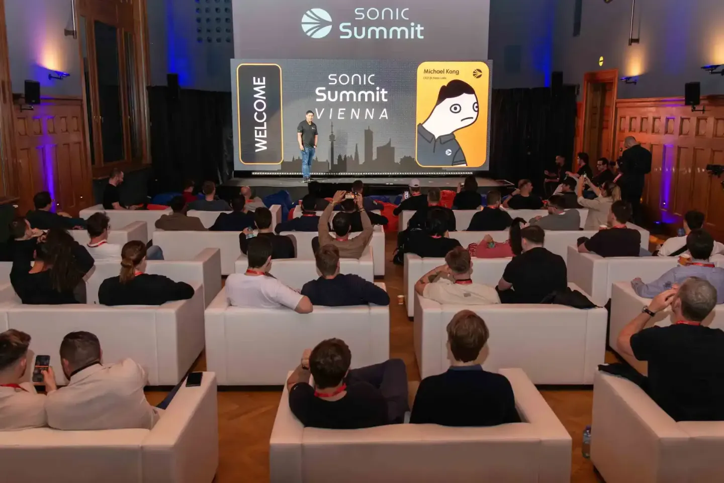 Publikum sitzt auf weißen Sesseln beim Sonic Summit Vienna, Eventfotograf dokumentiert die Konferenz