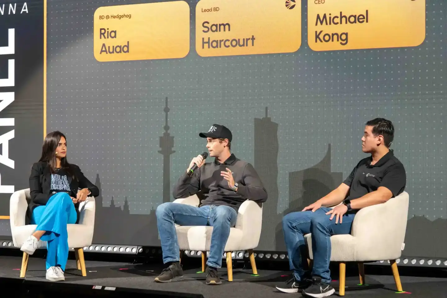 Drei Personen sitzen auf einer Bühne beim Sonic Summit Event in Wien und diskutieren vor Publikum, Eventfotografie Wien