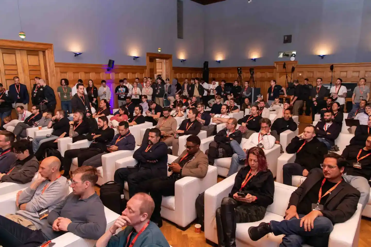 Konferenzraum mit etwa 100 Teilnehmern beim Sonic Summit Event, viele sitzen in weißen Sesseln, professionelle Eventfotografi