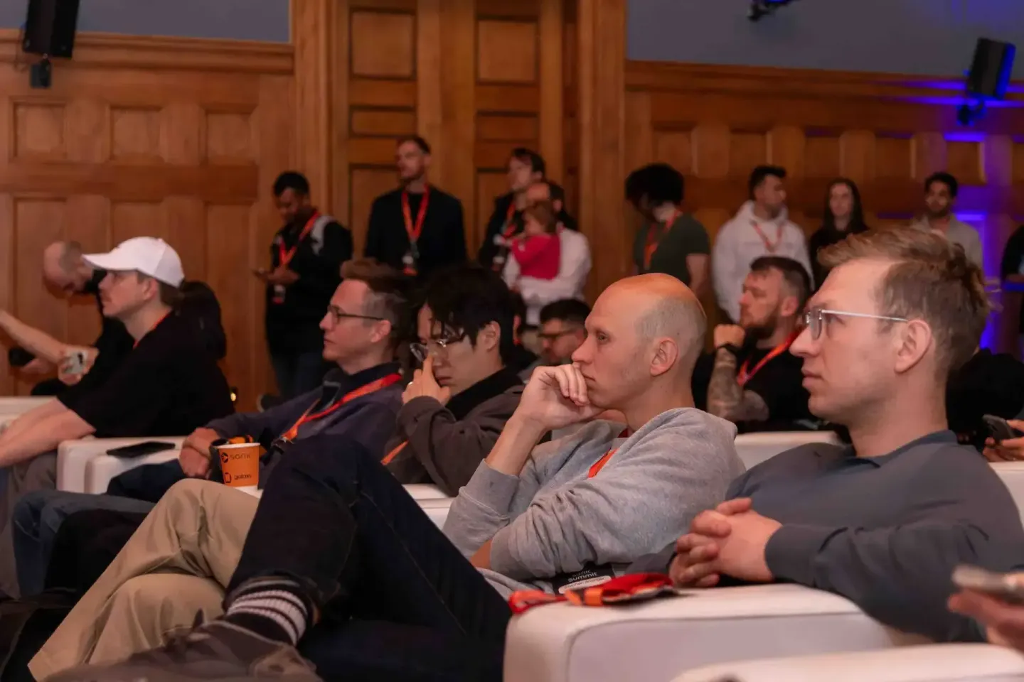 Publikum sitzt aufmerksam in einem holzgetäfelten Saal beim Sonic Summit Event. Eventfotografie Wien dokumentiert die konzent