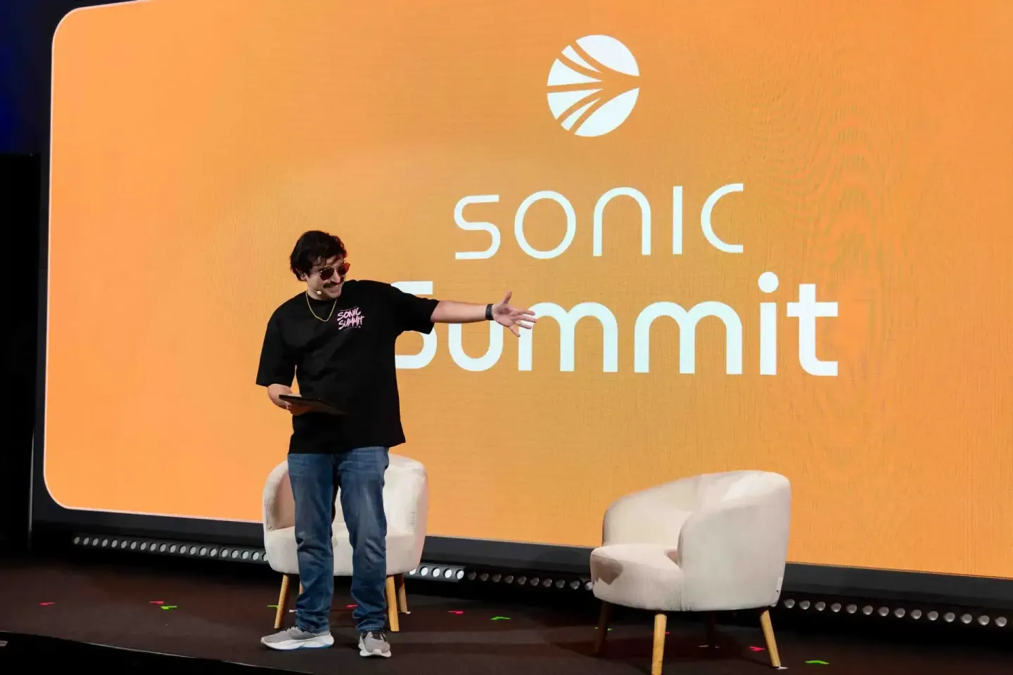 Speaker auf der Bühne des Sonic Summit mit orangem Hintergrund und Logo - Eventfotografie Wien
