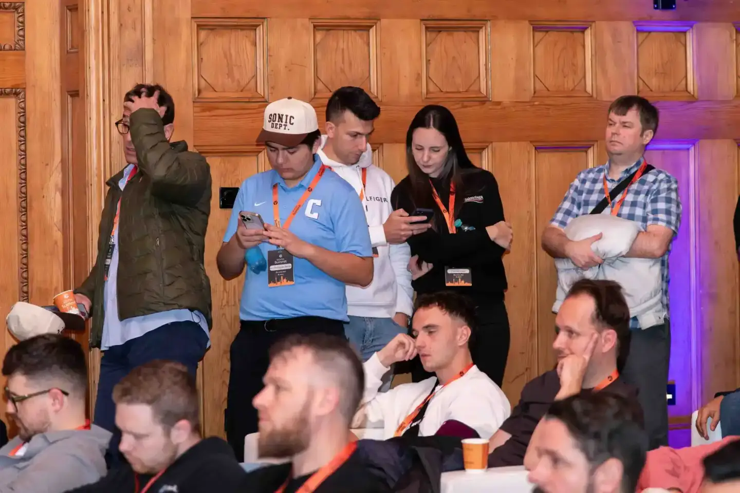 Teilnehmer beim Sonic Summit Event in Wien stehen zusammen, tragen Lanyards und diskutieren - Eventfotografie Wien