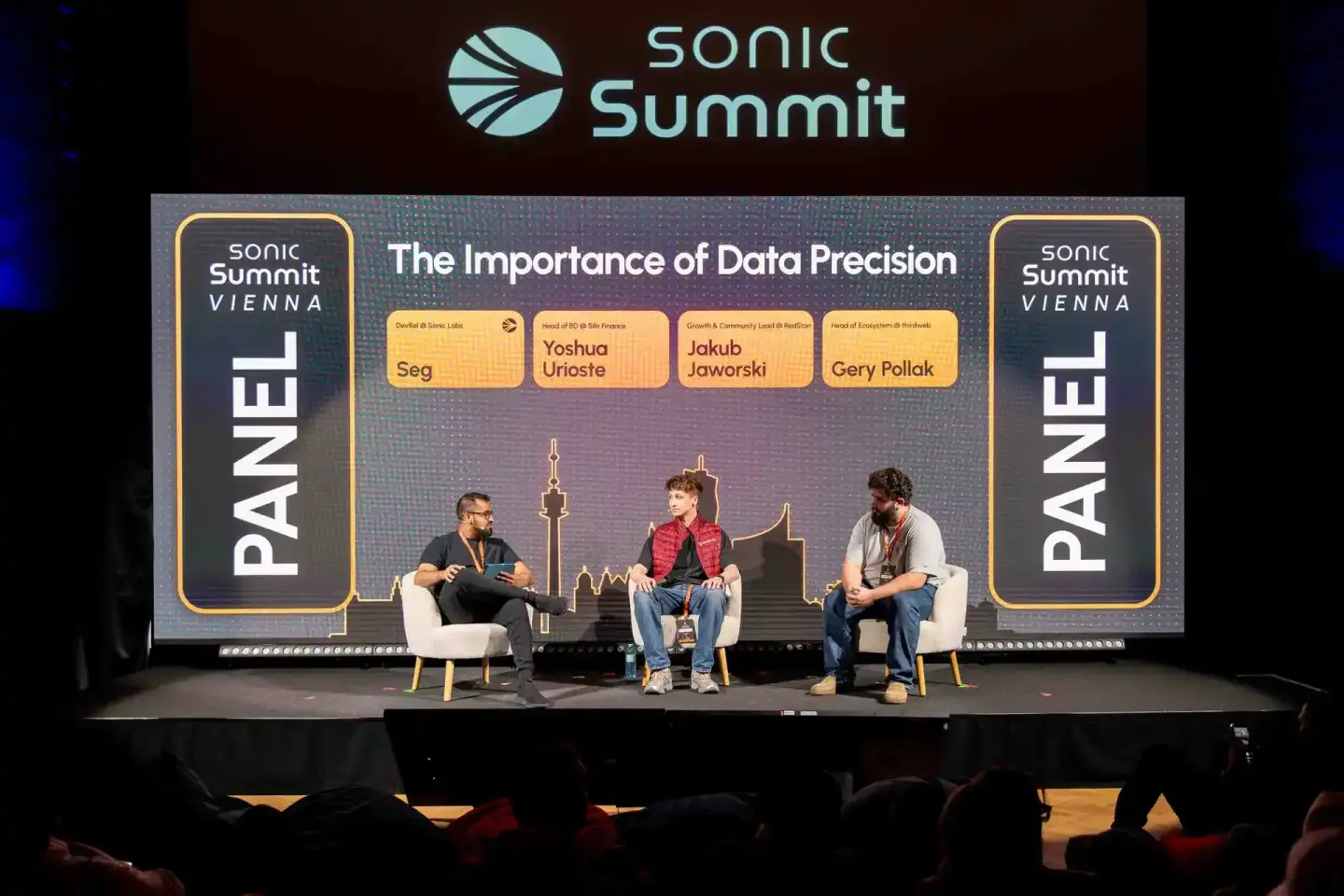 Podiumsdiskussion bei Sonic Summit Vienna mit vier Panelisten auf der Bühne zum Thema Datenpräzision, professionelle Eventfot