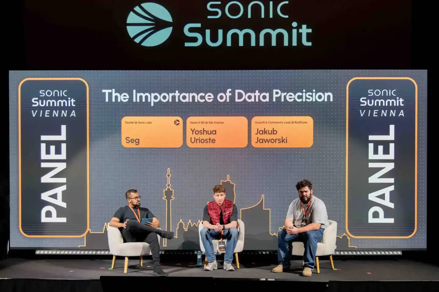 Podiumsdiskussion bei Sonic Summit Vienna mit drei Panelisten auf der Bühne zum Thema Datenpräzision - Eventfotografie Wien