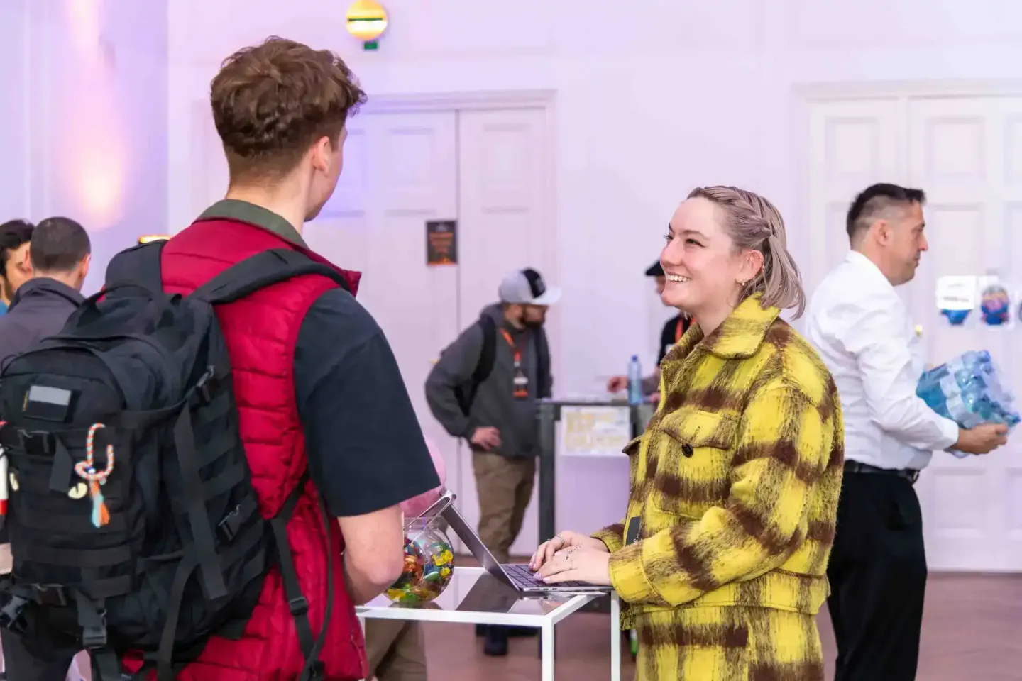 Eventfotograf dokumentiert Gespräch zwischen zwei Besuchern auf dem Sonic Summit in Wien, Frau in gelbem Muster-Jacket mit La