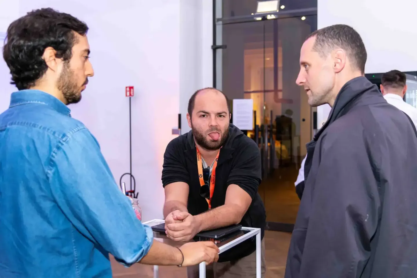 Drei Männer im Gespräch auf dem Sonic Summit Event in Wien, Eventfotograf dokumentiert die Networking-Situation