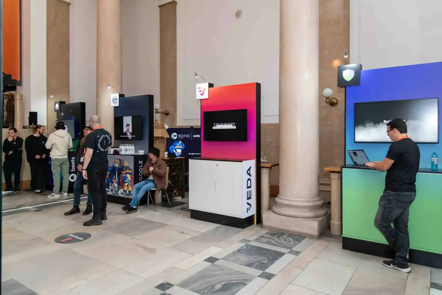 Besucher beim Sonic Summit Event in Wien mit interaktiven Display-Stationen und Eventfotograf im Einsatz