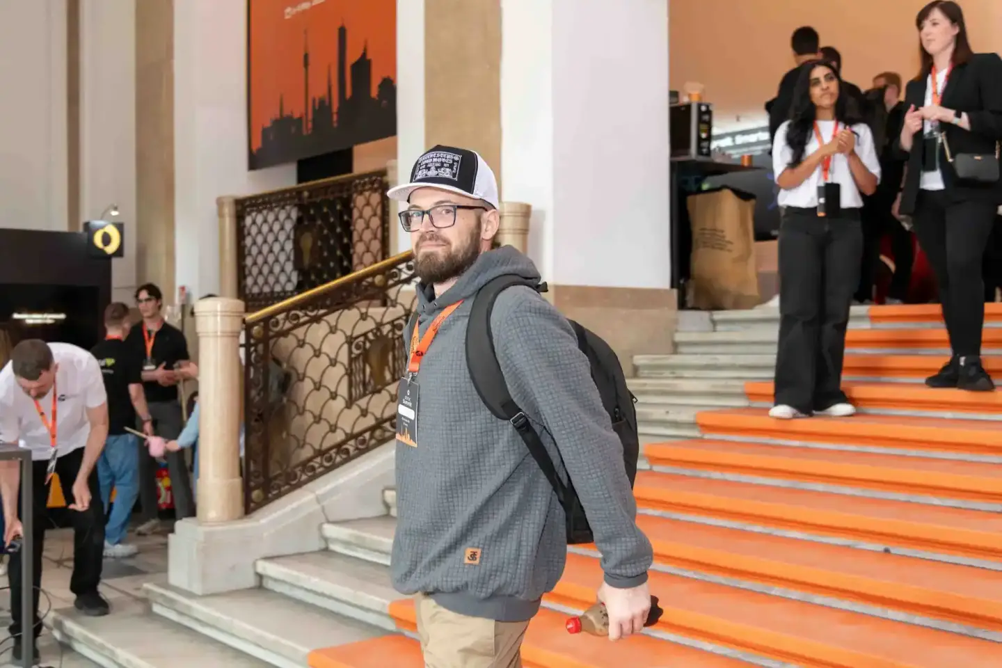 Besucher beim Sonic Summit Event in Wien, professionelle Eventfotografie in eleganter Veranstaltungshalle mit orange Teppich