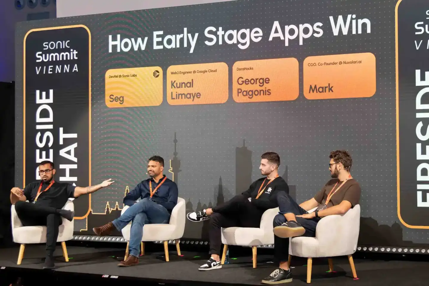 Podiumsdiskussion beim Sonic Summit Vienna: Vier Sprecher sitzen auf der Bühne, im Hintergrund die Wiener Skyline und das The
