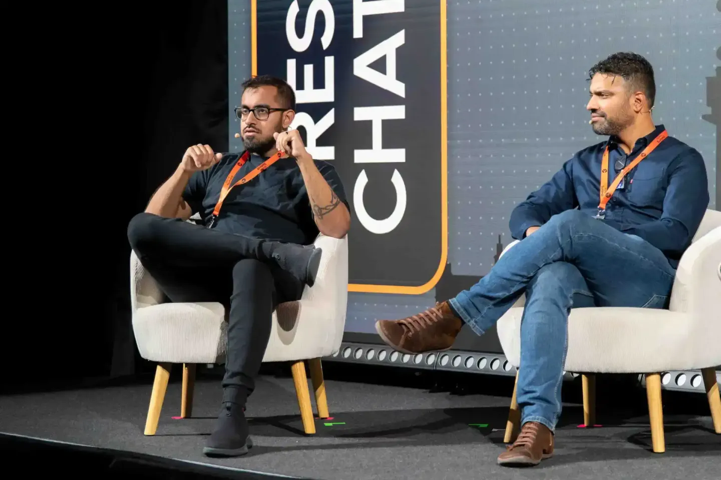 Zwei Moderatoren diskutieren auf der Sonic Summit in Wien - professionelle Eventfotografie einer Konferenzszene