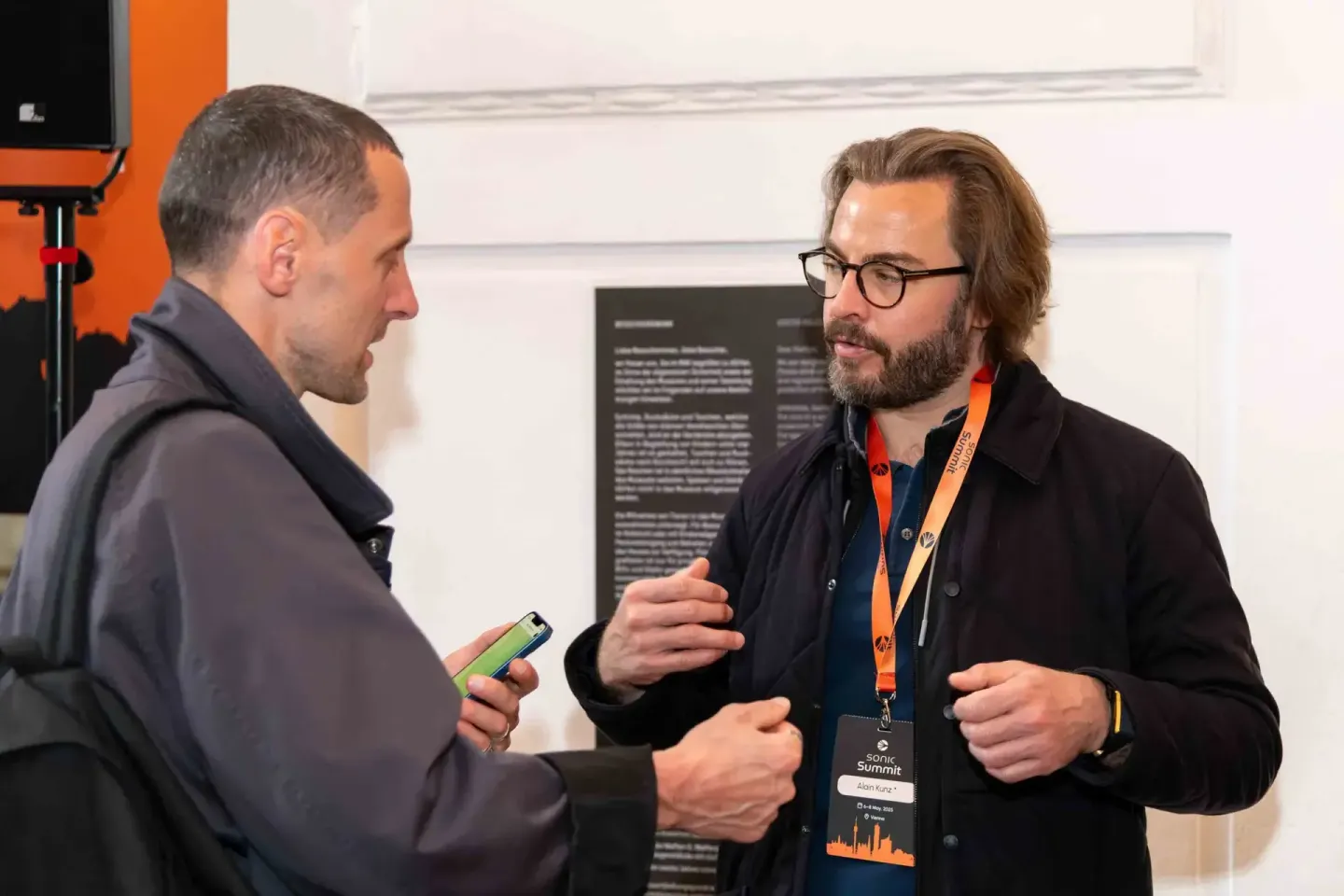 Zwei Männer im Gespräch bei der Sonic Summit in Wien - der Eventfotograf dokumentiert die Konversation an einem Veranstaltung